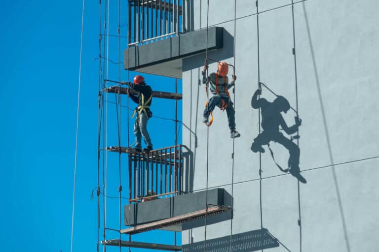 couple-workers-fixing-climbing-scaffolding-while-following-all-safety-measures