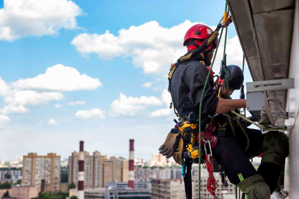 industrial-mountaineering-worker-hangs-residential-building-while-installing